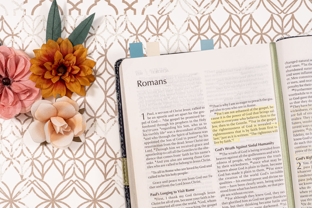 Open book on a decorative surface with flowers and bookmarks