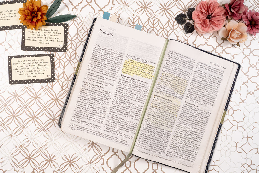 Open book on a decorative surface with flowers and cards
